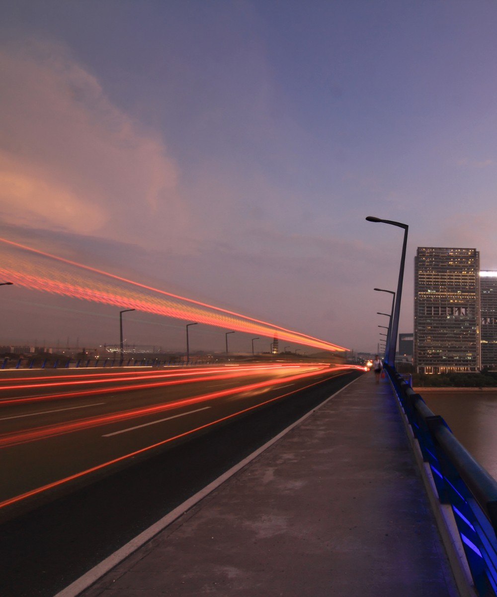 Lichtspuren auf einer Brücke bei Abenddämmerung als Metapher für dynamischen Linkaufbau