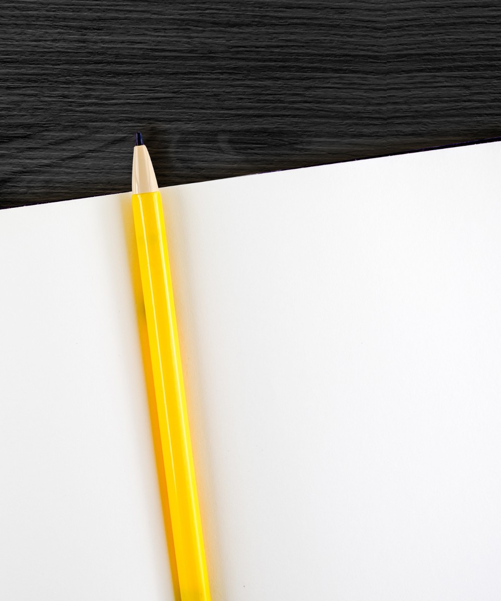 Gelber Bleistift auf leerem Blatt Papier, bereit fÃ¼r professionelle Texterstellung